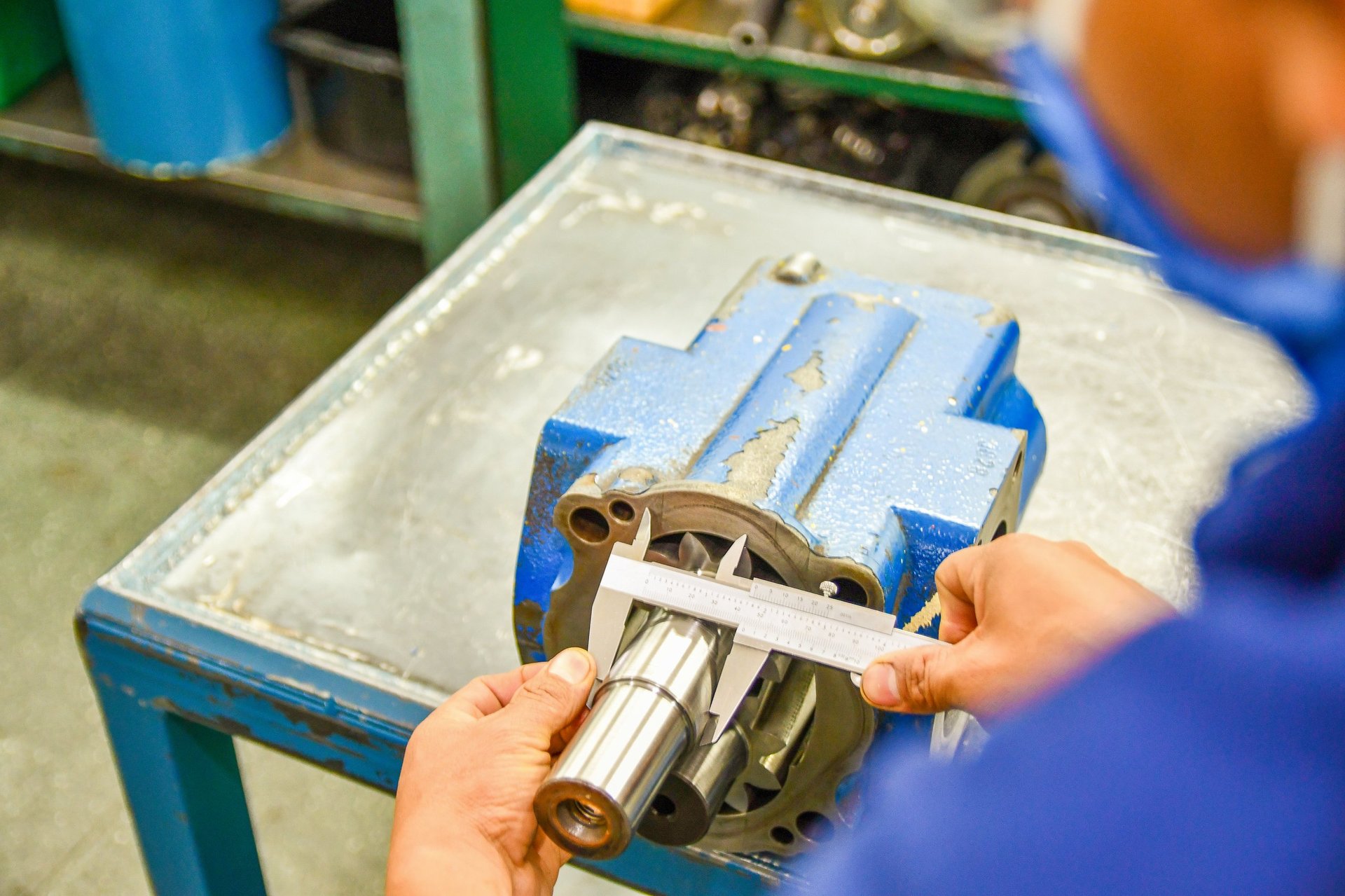Technician measuring hydraulic pump with precision tools