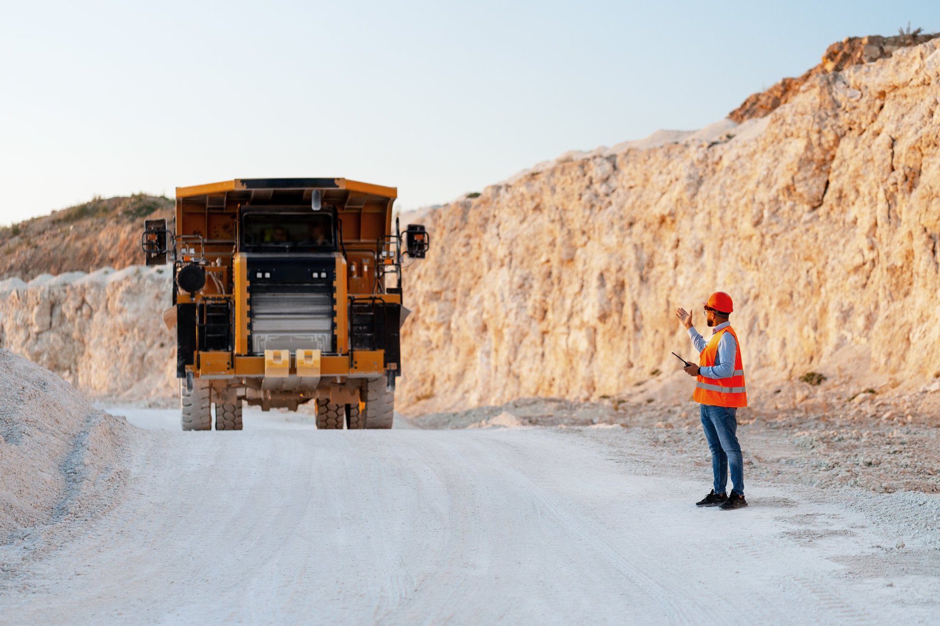Foreman directing truck in quarry using tablet